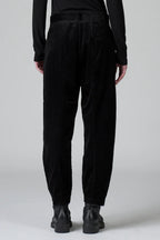 Person wearing black pants and black shoes on a white background