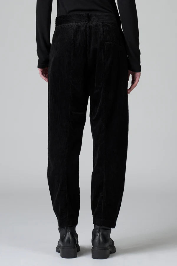 Person wearing black pants and black shoes on a white background