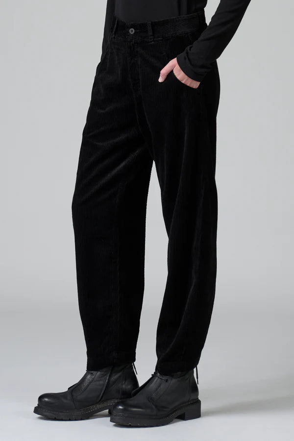 Person wearing black pants and shoes on a plain background