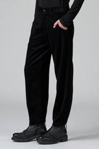 Person wearing black pants and shoes on a plain background