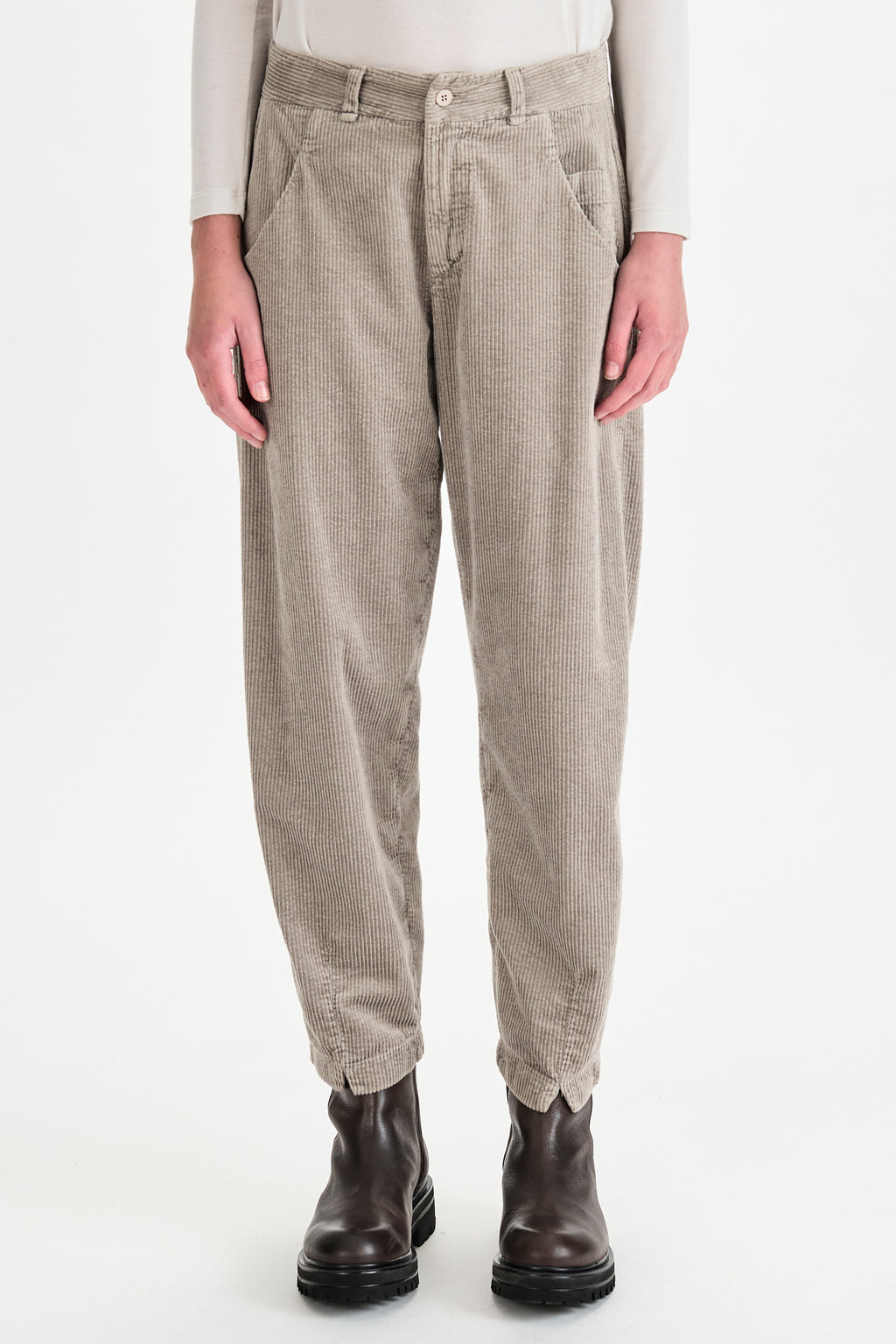 Person wearing beige checkered pants with a white background