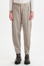 Person wearing beige checkered pants with a white background