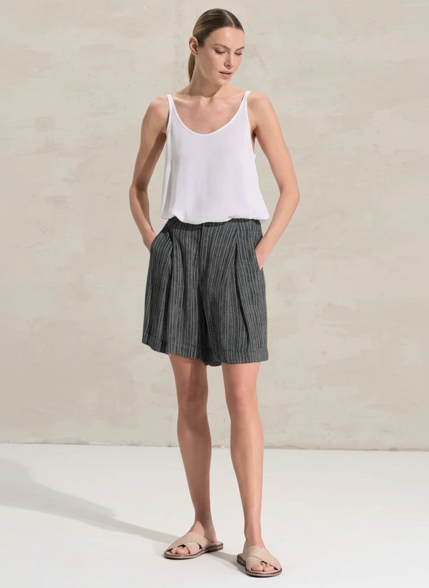 women wearing Transit shorts with flared leg, made of viscose fabric printed with vertical stripes. The garment is characterized by the full belt on the front and with elastic on the back, rounded pockets and 2 deep flaps on the front, while on the back 2 aesthetic welt pockets. Garment washed and dyed garment.
