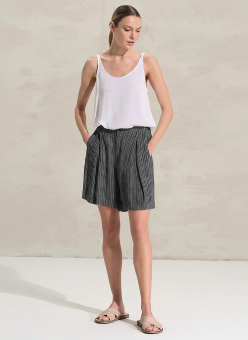 women wearing Transit shorts with flared leg, made of viscose fabric printed with vertical stripes. The garment is characterized by the full belt on the front and with elastic on the back, rounded pockets and 2 deep flaps on the front, while on the back 2 aesthetic welt pockets. Garment washed and dyed garment.
