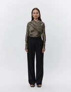 A person standing in a head-on pose wearing Charles Classic Pants in black, which are mid-rise with a wide-leg cut.