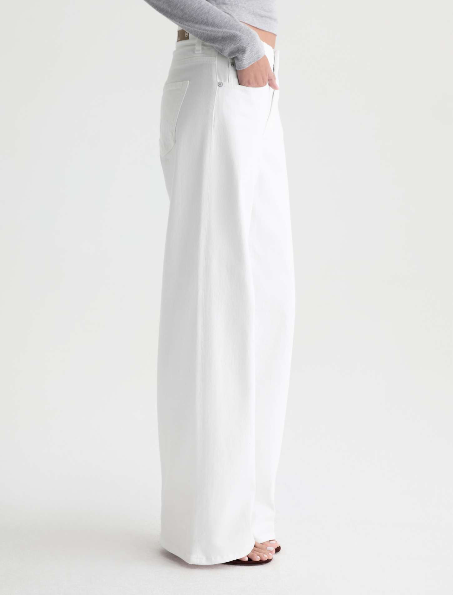White pants worn by a person on a white background