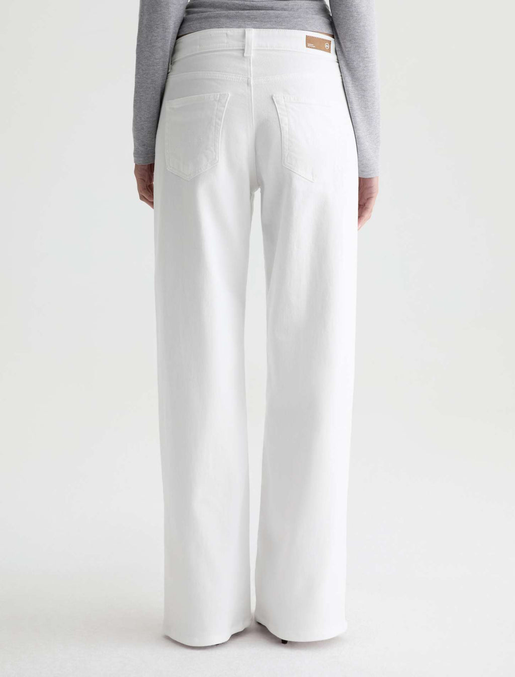White pants worn by a person on a white background