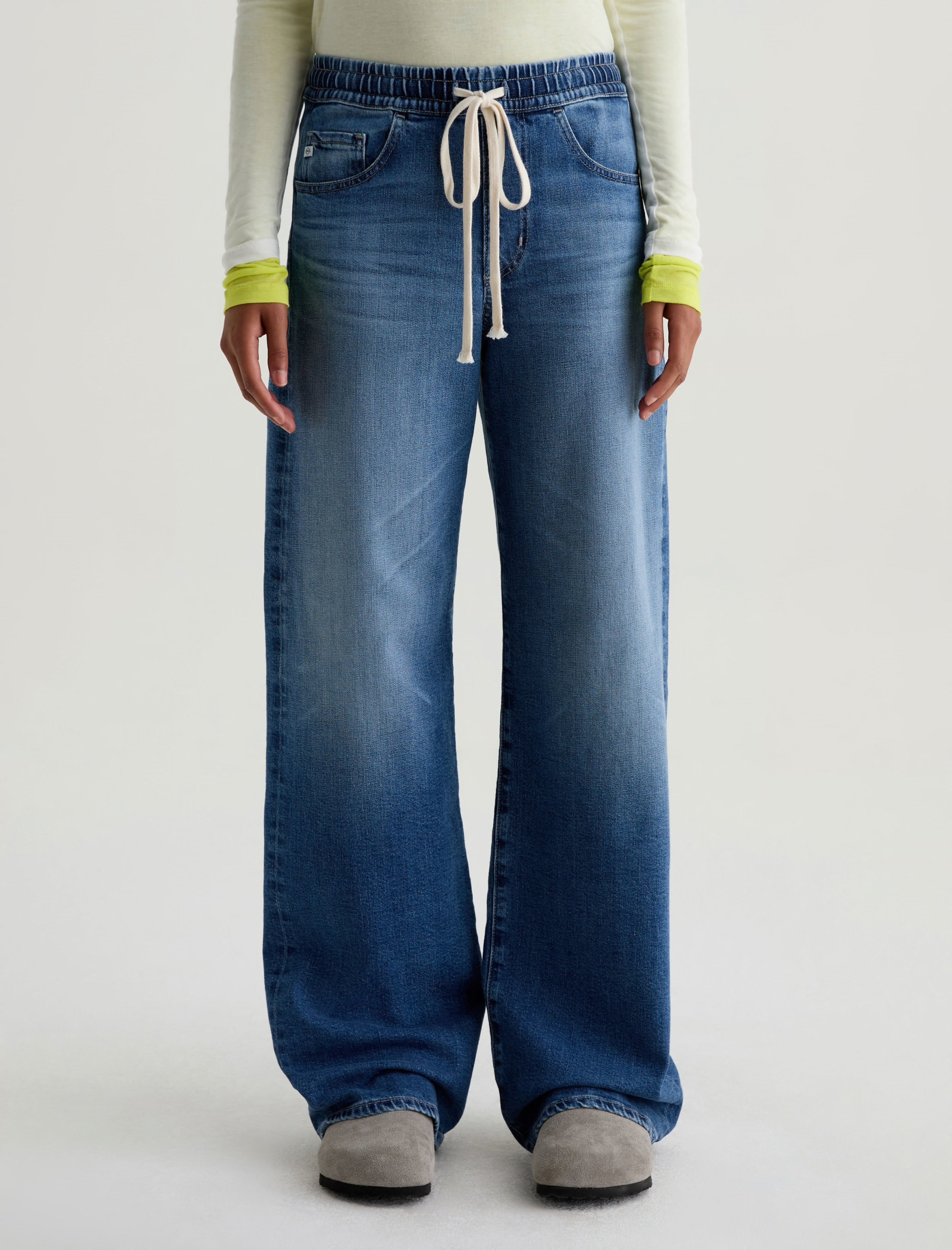 Person wearing blue jeans with a white background