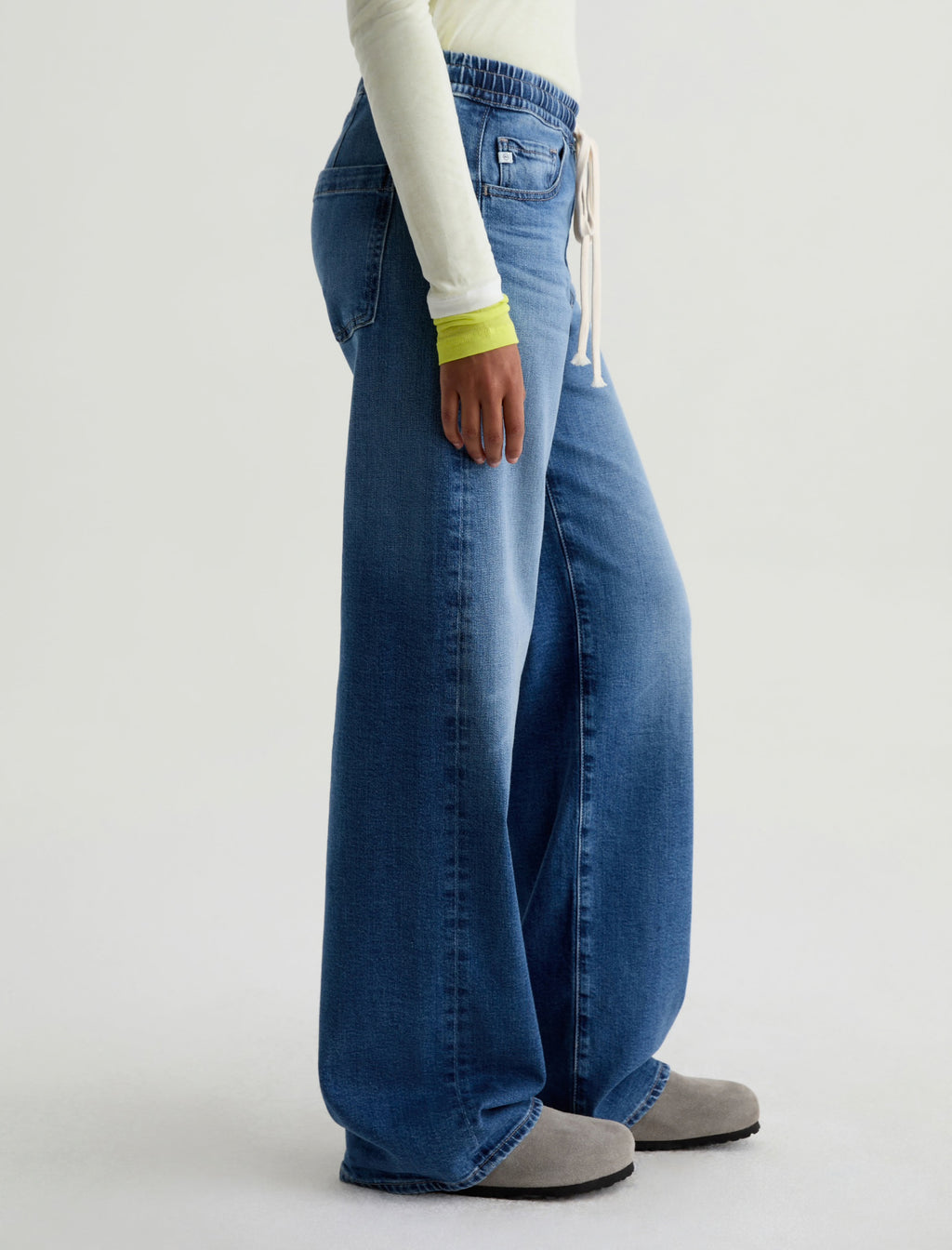 Person wearing blue jeans on a white background