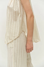 Person wearing a light-colored dress with a plain background