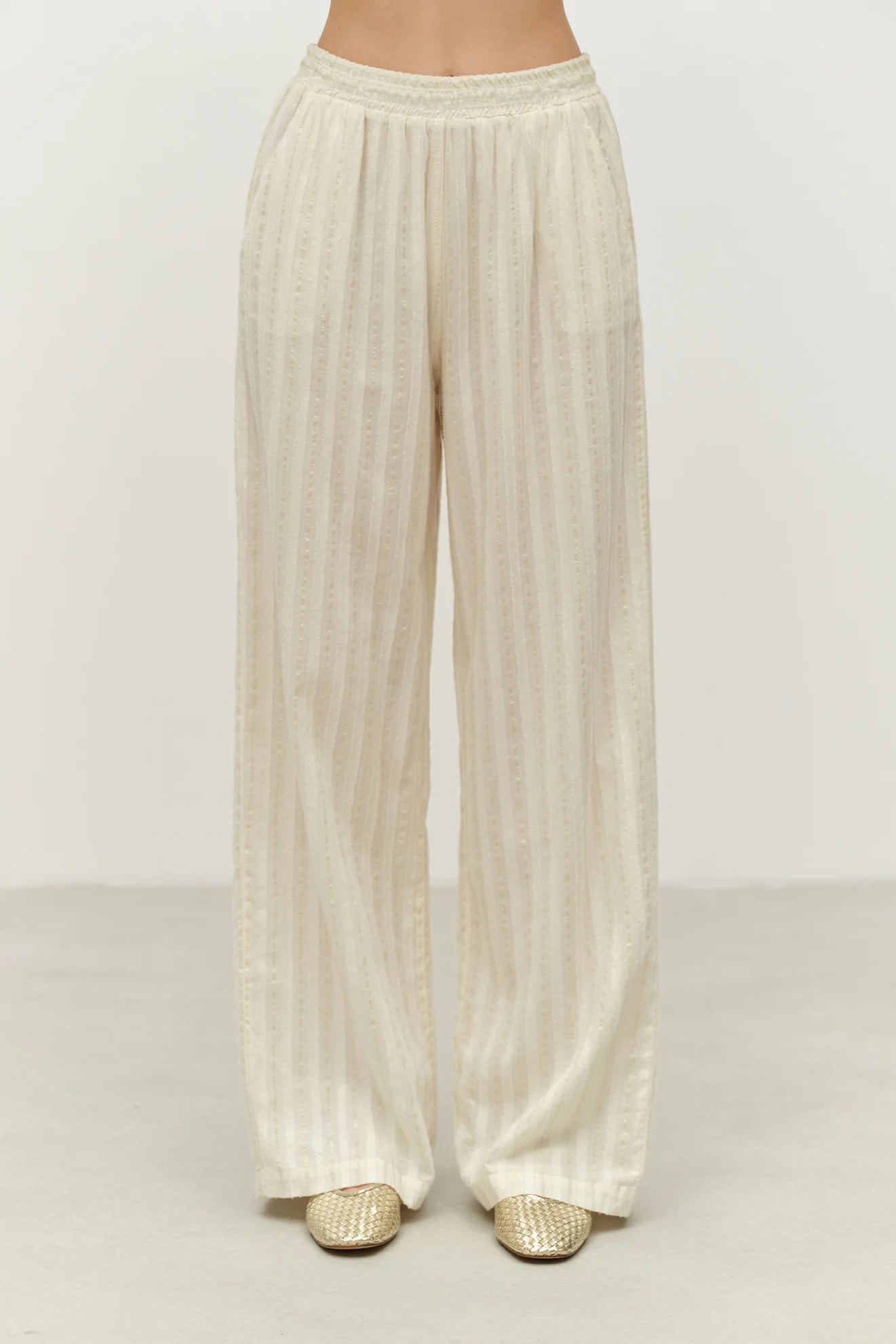 Beige wide-leg pants on a plain background