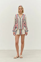 Woman wearing a striped shirt and shorts set on a plain background