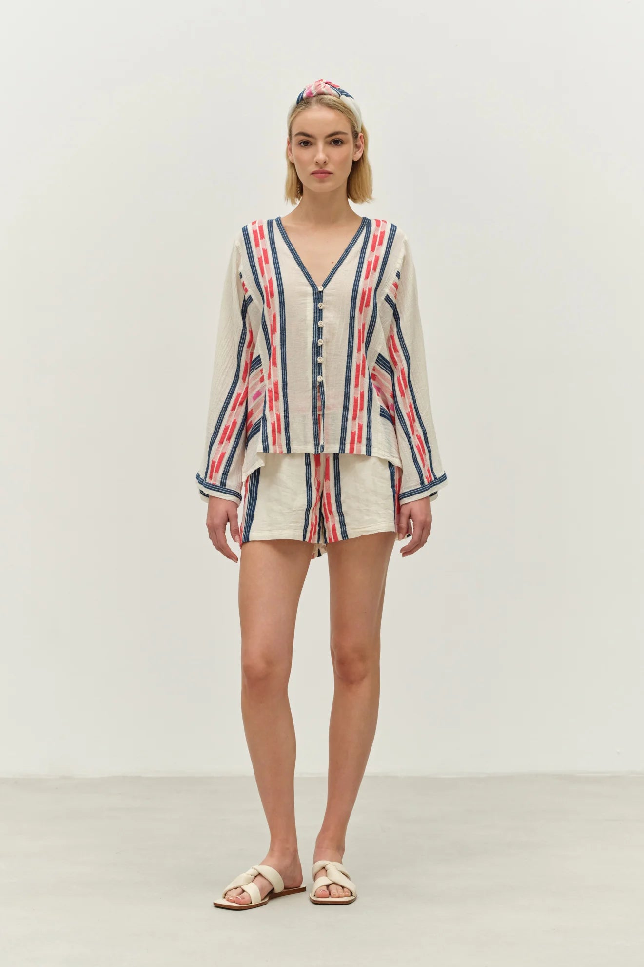 Woman wearing a striped shirt and shorts set on a plain background