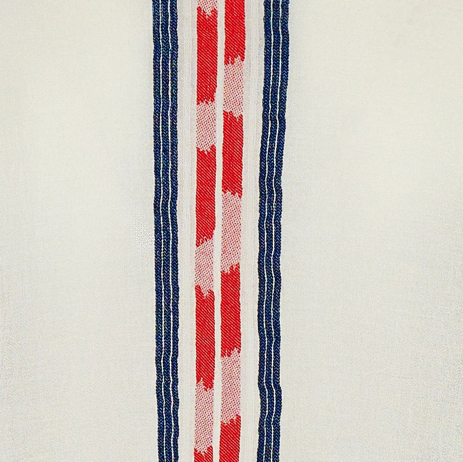 Close-up of a fabric with red, white, and blue stripes on a beige background