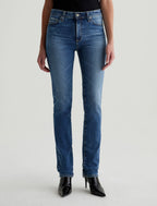 A person standing wearing a pair of blue jeans and black boots.