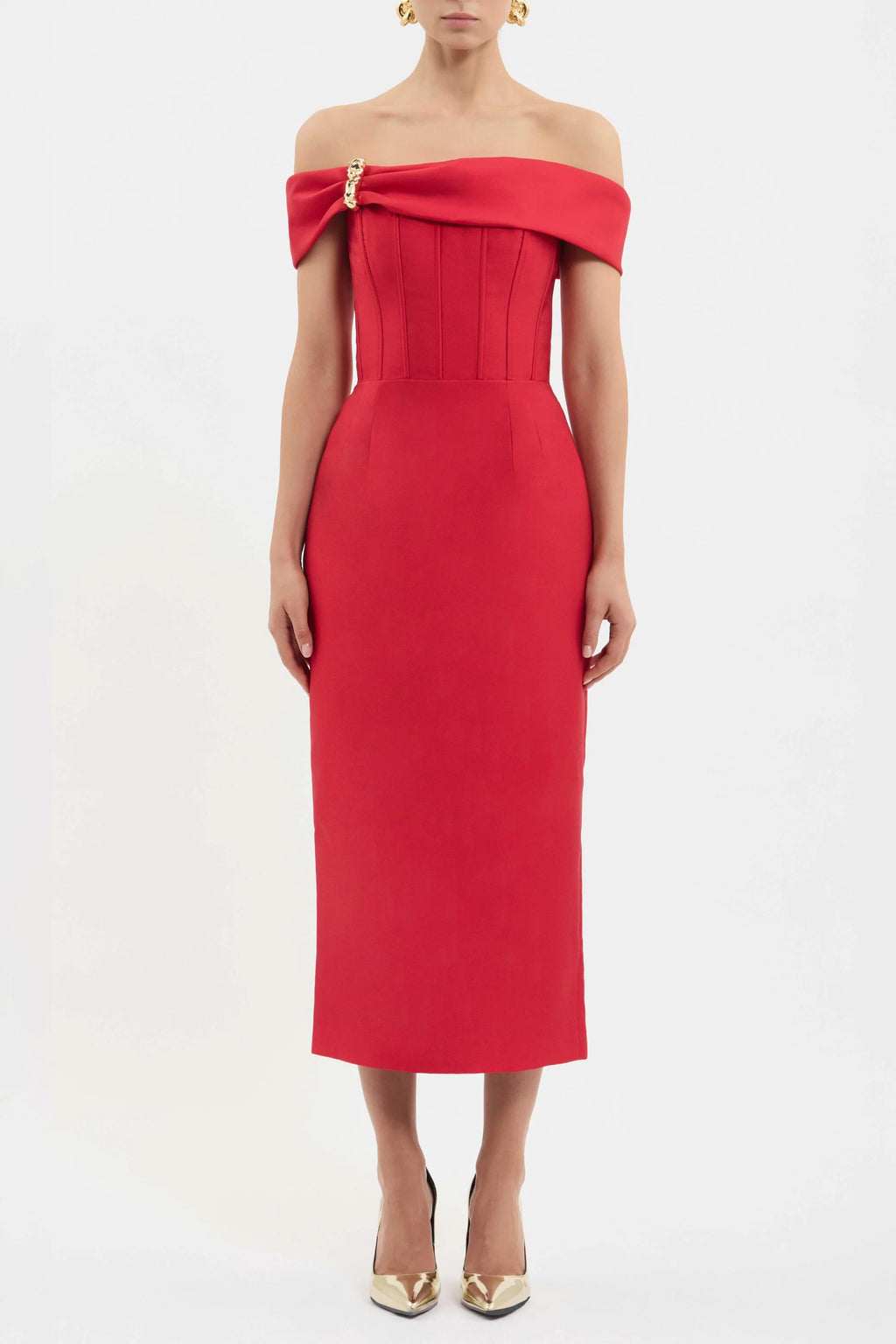 A model wearing a bright red off-the-shoulder midi dress with a structured corset-style bodice and a gold zipper detail at the neckline, paired with gold pointed-toe heels against a plain white studio background.