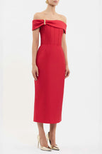A model wearing a bright red off-the-shoulder midi dress with a structured bodice and pleated detailing, paired with gold high heels against a plain white studio background.