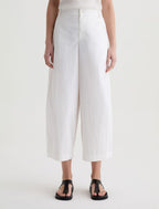 Person wearing white wide-leg pants on a plain background