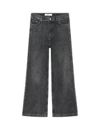 Black jeans with studded details on a white background