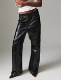 Black leather pants worn by a person on a plain background
