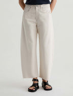 Person wearing beige wide-leg pants on a white background
