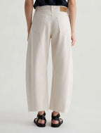 Person wearing beige wide-leg pants on a plain background