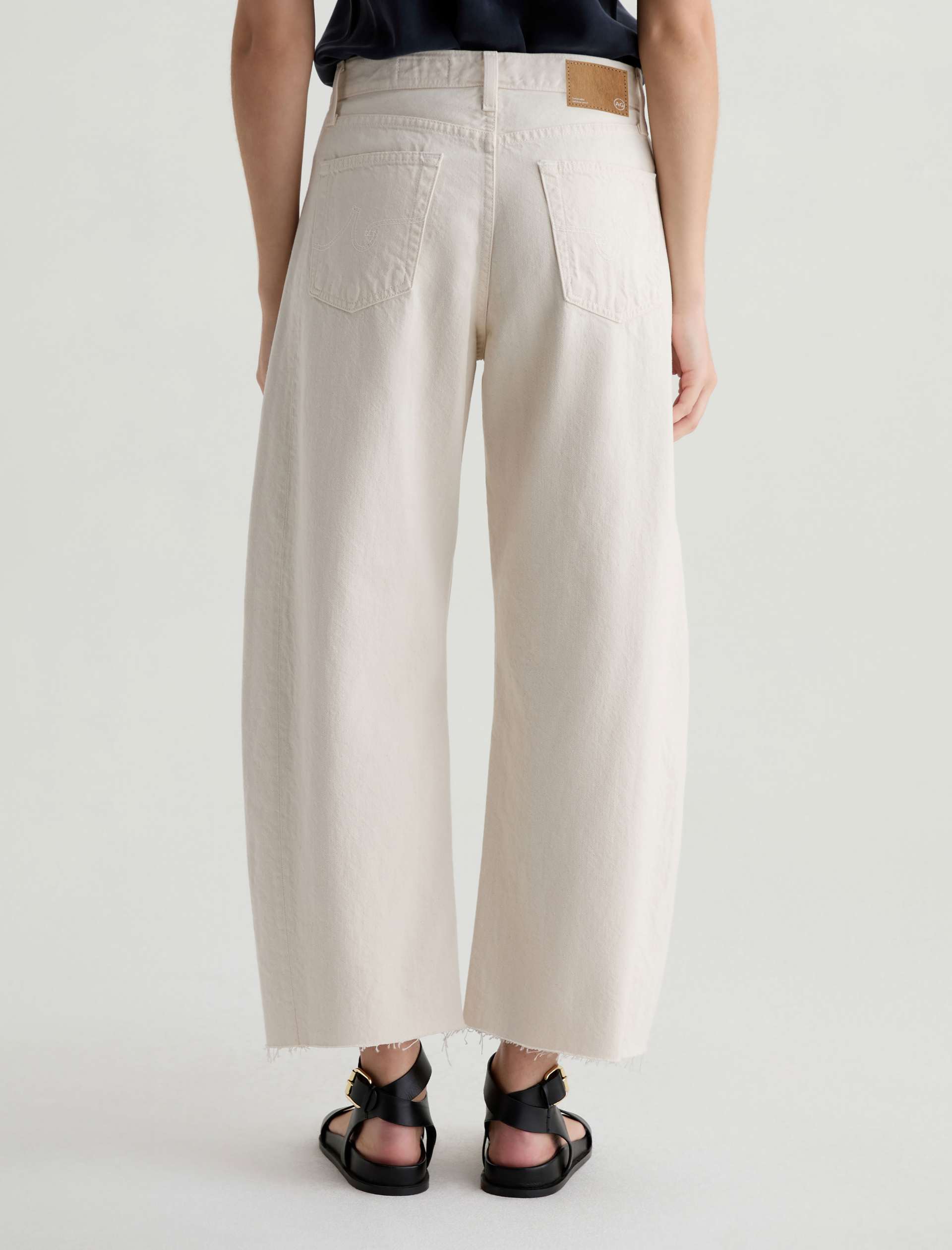 Person wearing beige wide-leg pants on a plain background