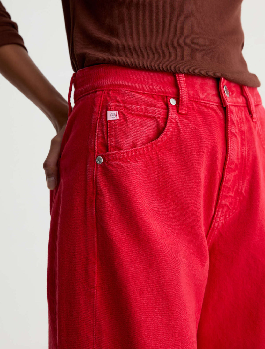 Red pants with a visible brand tag on a plain background