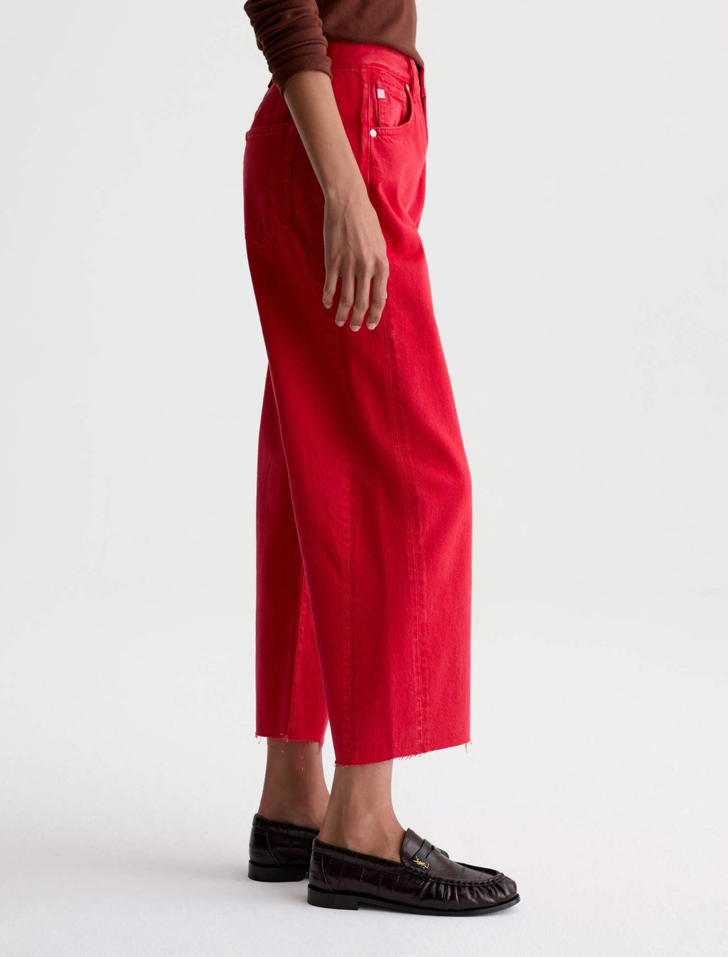 Person wearing red pants and brown shoes on a white background