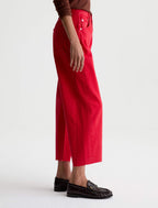 Person wearing red pants and brown shoes on a white background