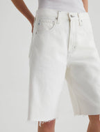 White denim skirt worn by a person on a white background