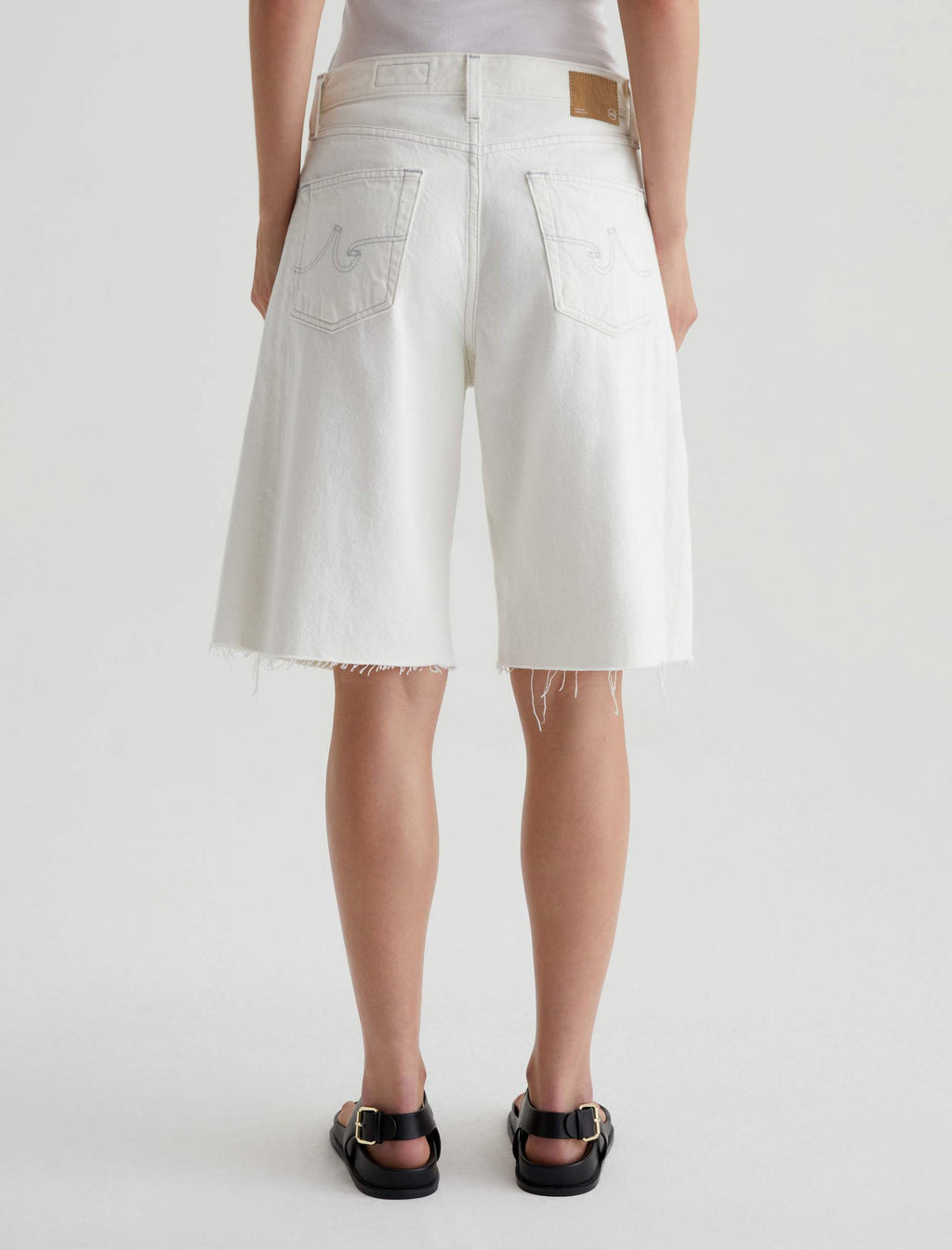 Person wearing white shorts on a plain background