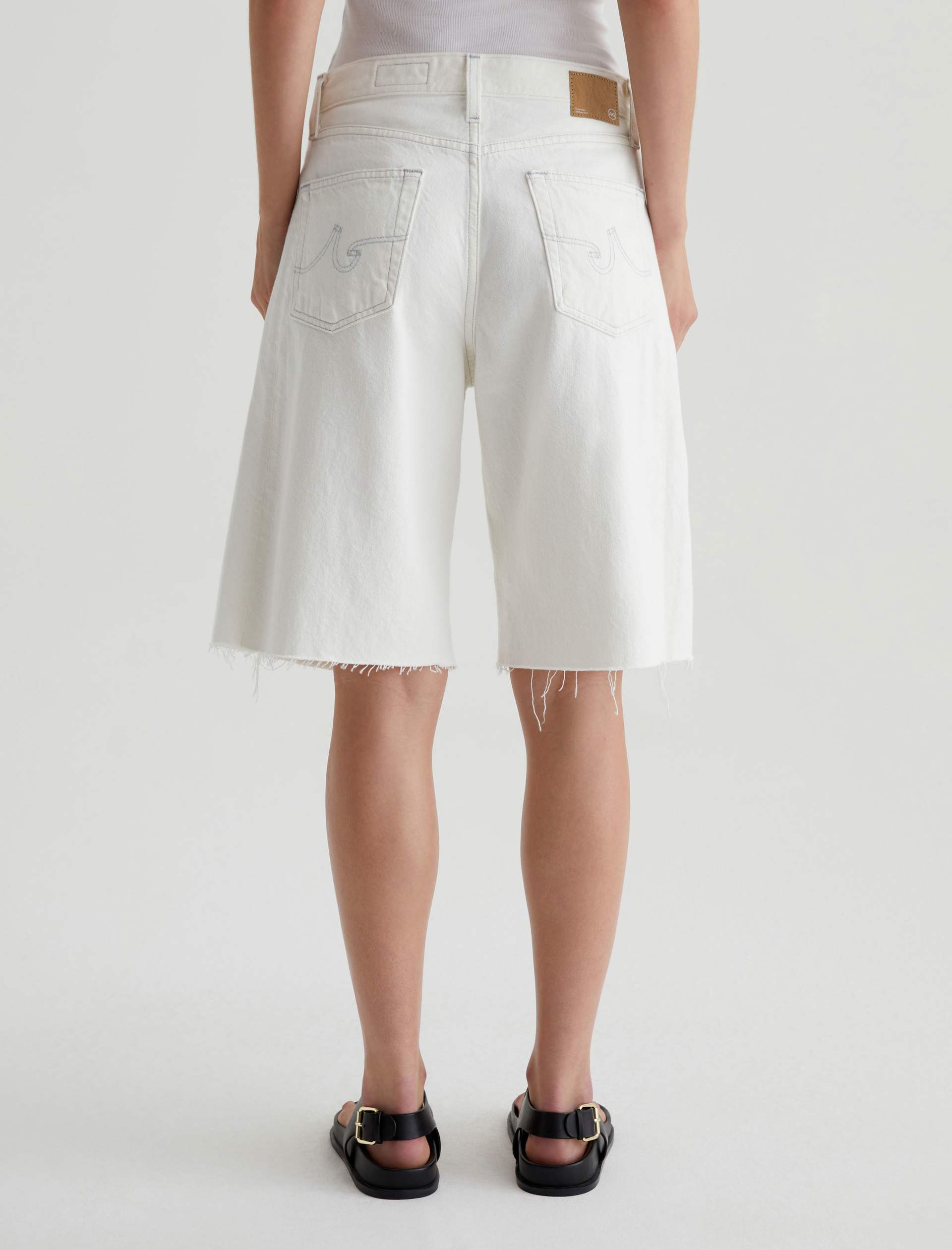 Person wearing white shorts on a plain background