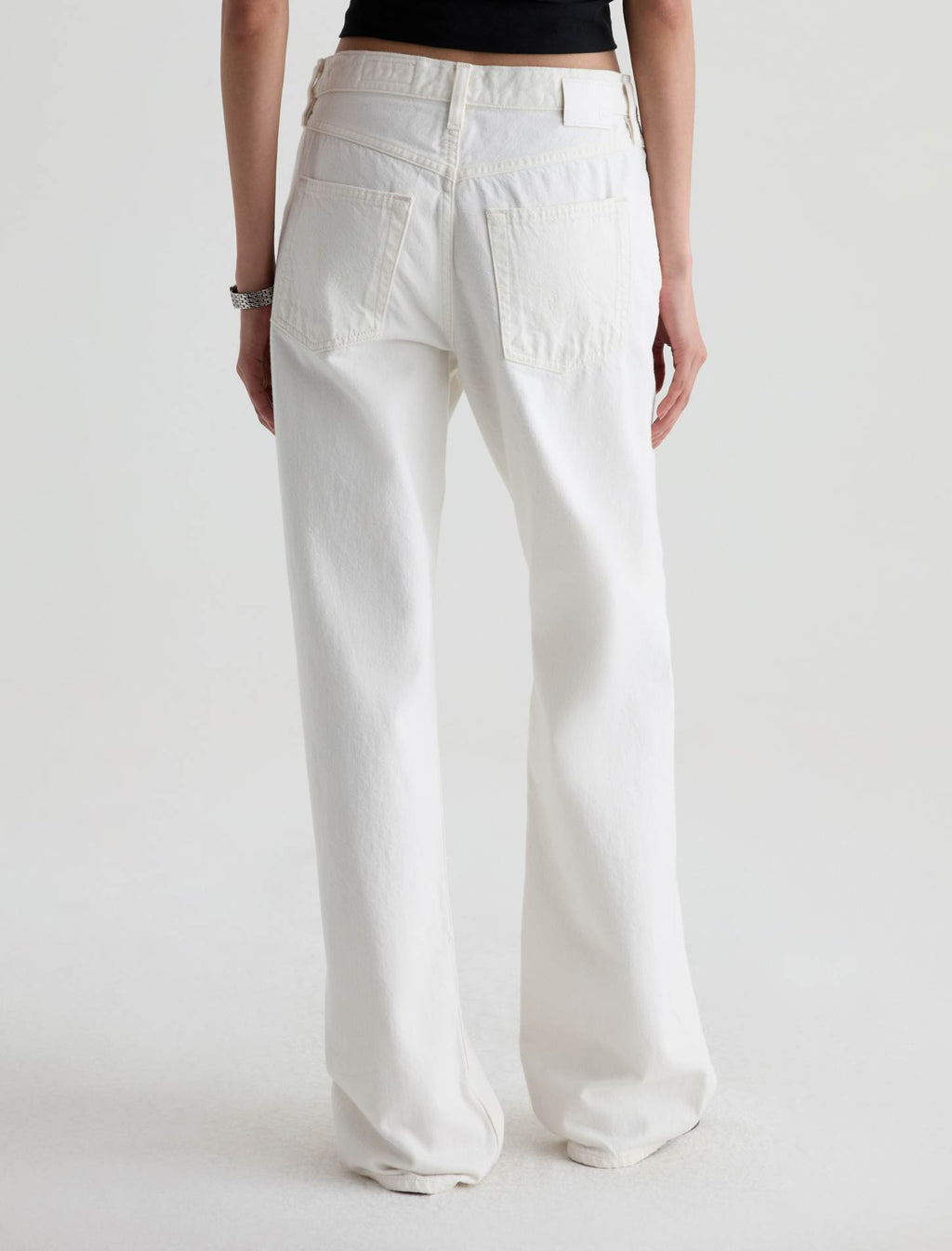 Person wearing white pants on a plain background