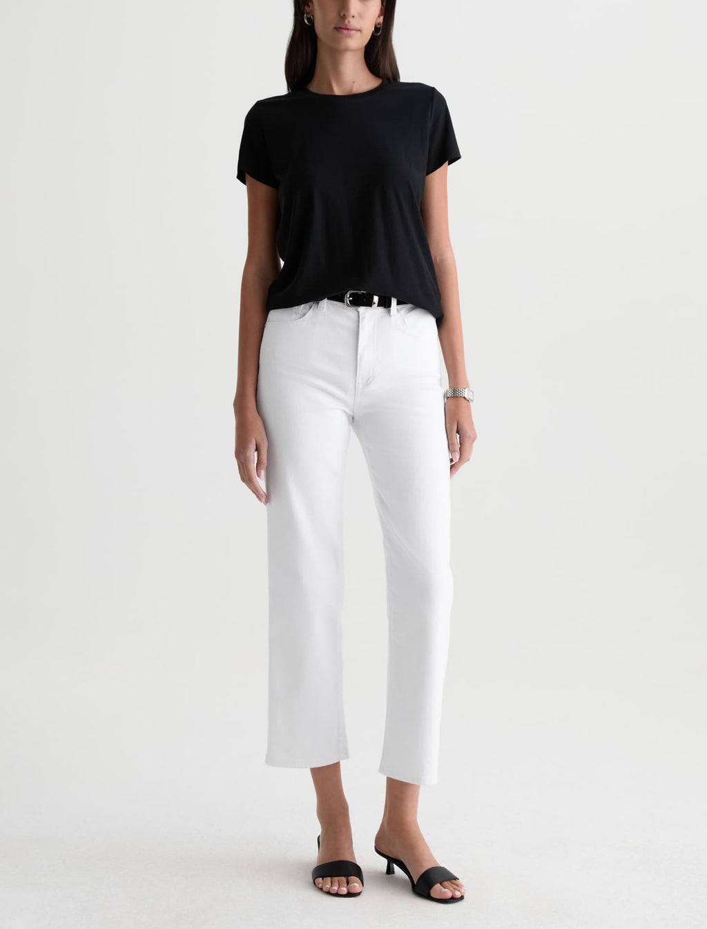 Person wearing a black t-shirt and white pants on a white background