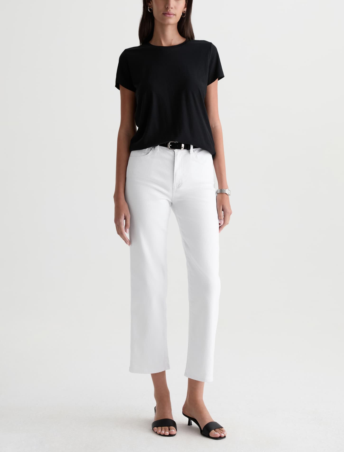 Person wearing a black t-shirt and white pants on a white background