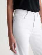 Person wearing white jeans and a black top on a plain background