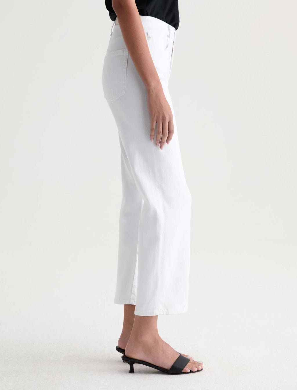 Person wearing white pants on a plain background