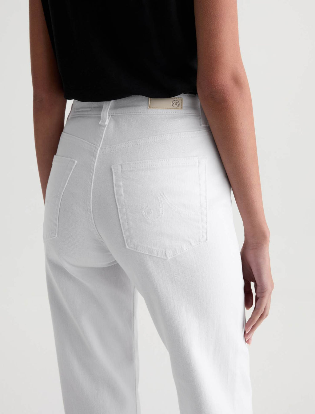 White jeans worn by a person on a white background