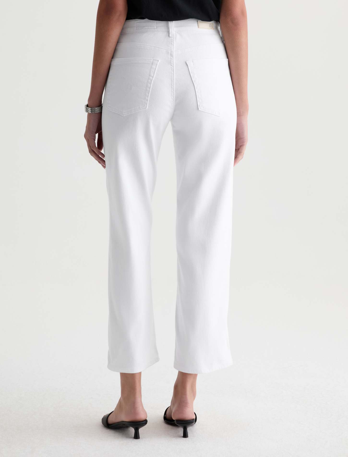 Person wearing white pants on a plain background