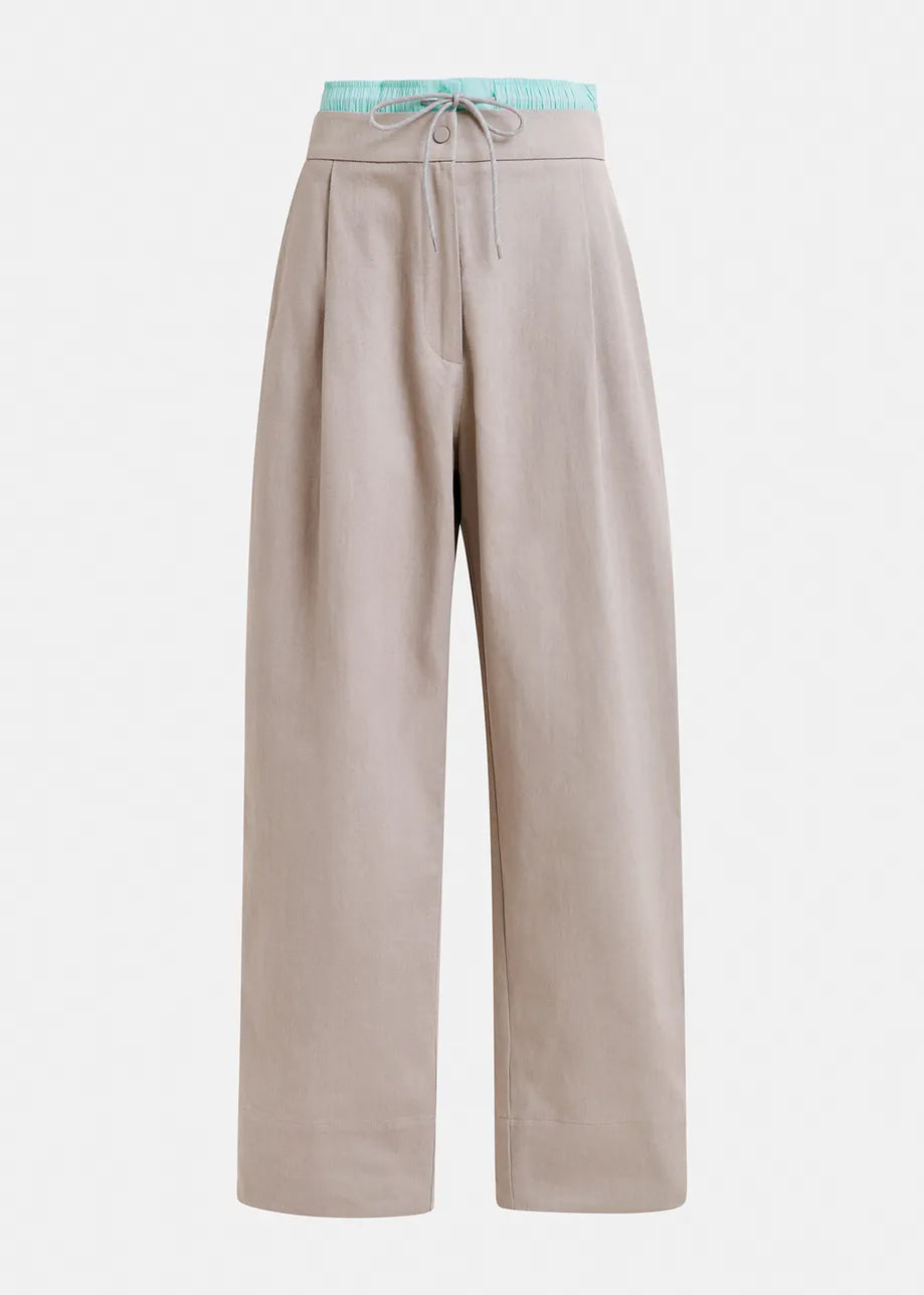A pair of beige hip pants with a contrast elastic waistband and Nimbus Cloud pattern.