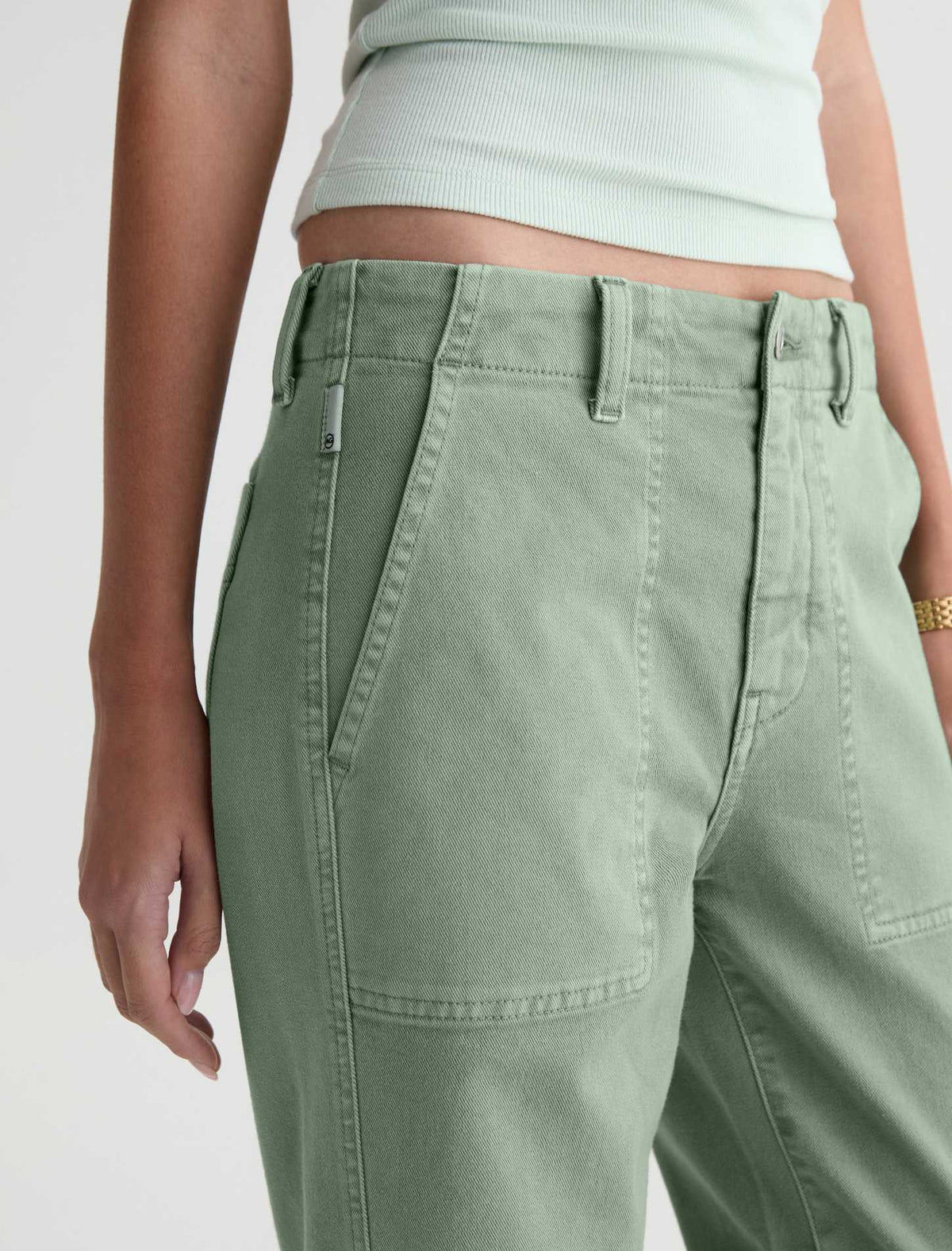 Close-up of a model wearing sage green wide-leg cargo pants with a ribbed light mint top, shown from the waist down against a plain white background.