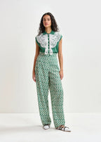 Woman wearing a green and white patterned outfit on a white background