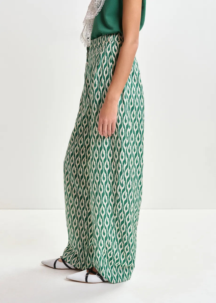 Green and white patterned skirt worn by a person on a white background