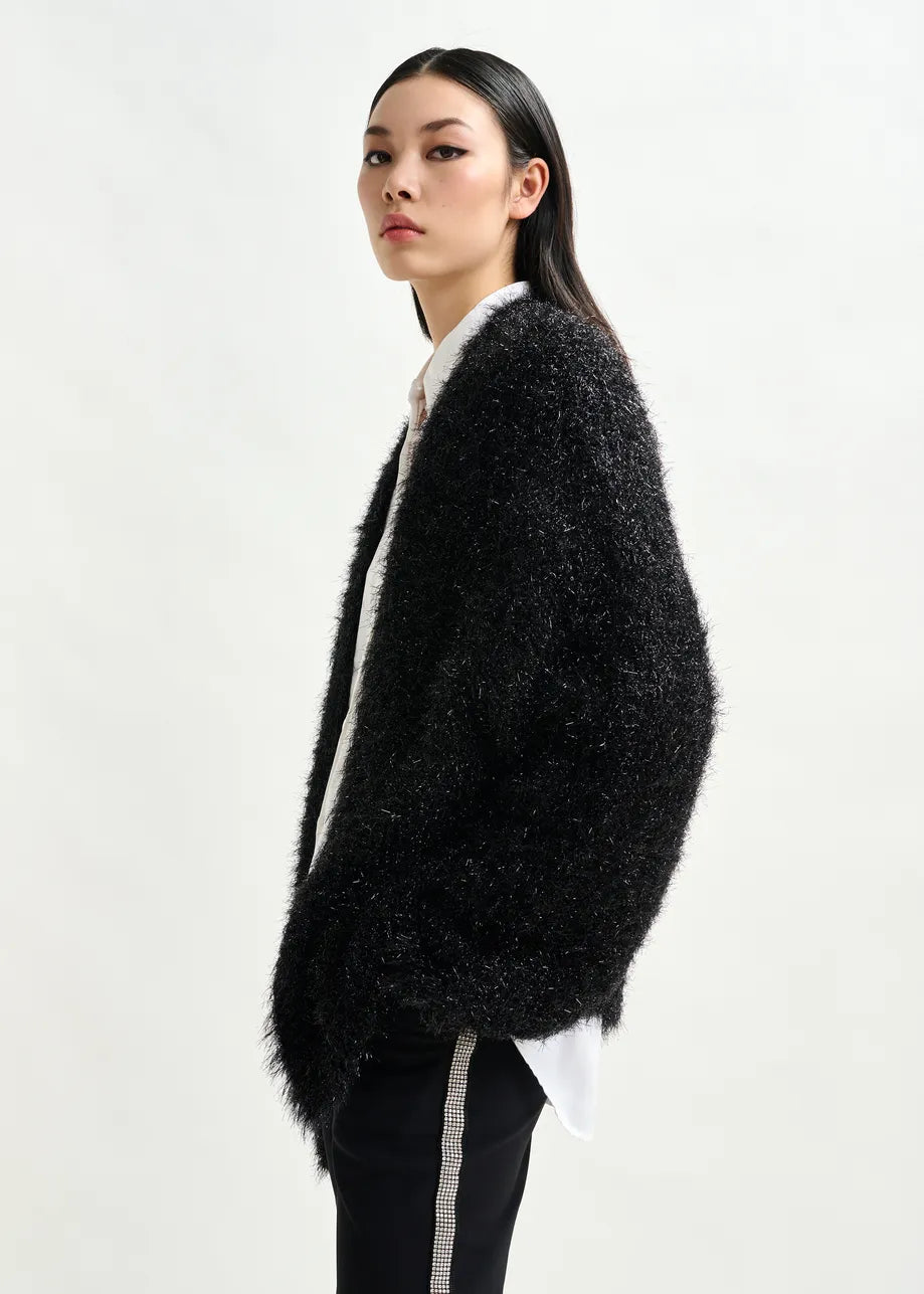 Woman wearing a black fluffy cardigan on a white background