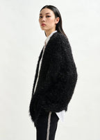 Woman wearing a black fluffy cardigan on a white background