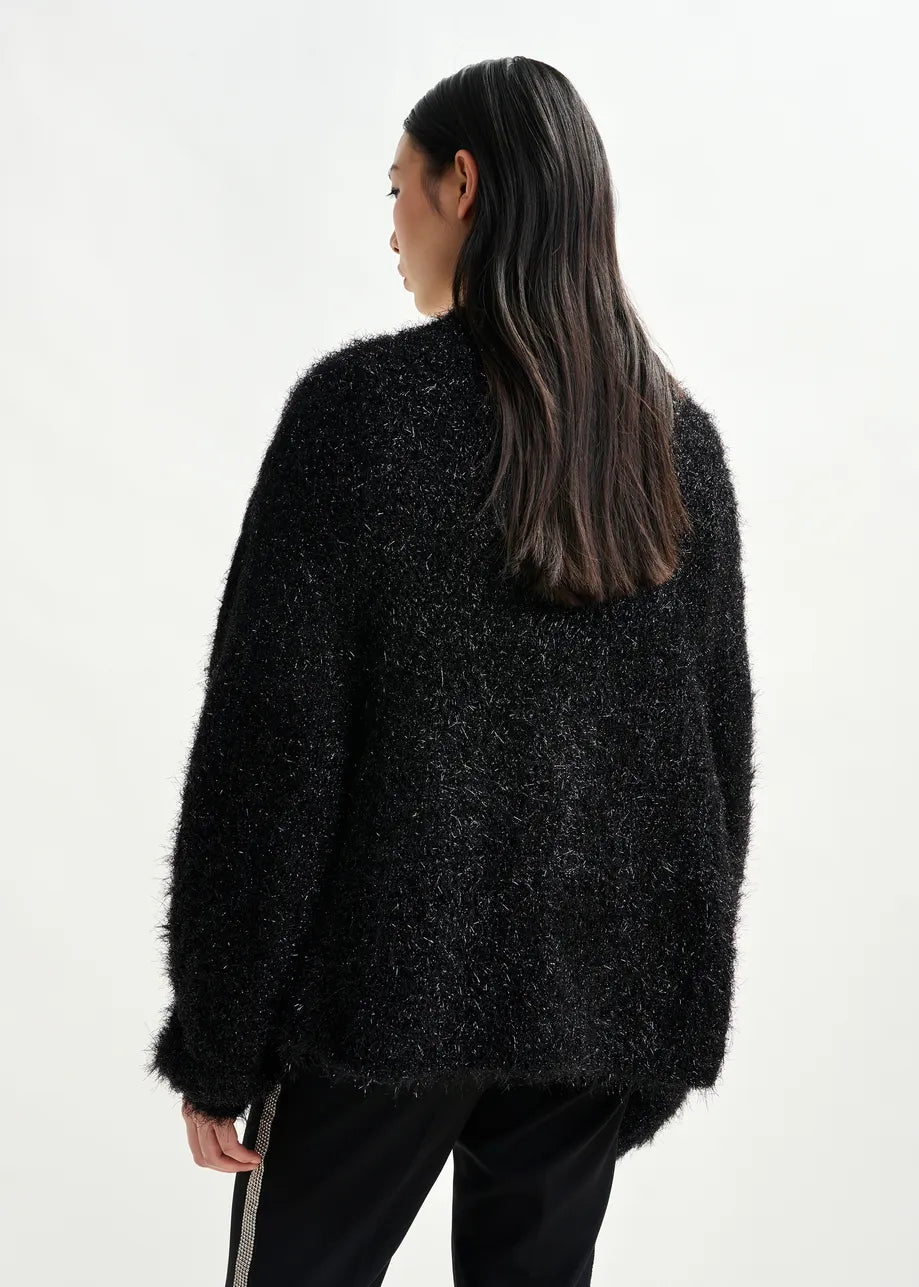 Person wearing a black textured sweater on a white background