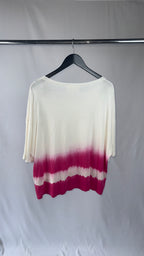 White and pink gradient top on a hanger against a plain background