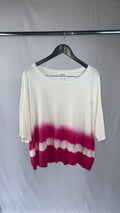 White and magenta tie-dye shirt on a hanger against a plain background