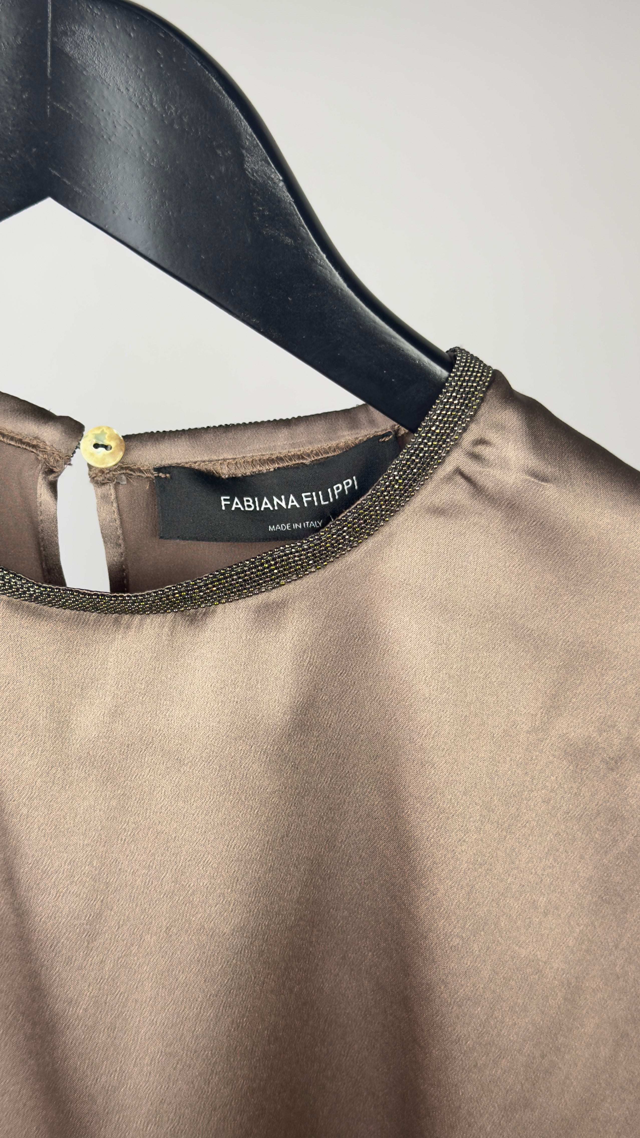 Brown garment on a hanger with 'Fabiana Filippi' label against a neutral background